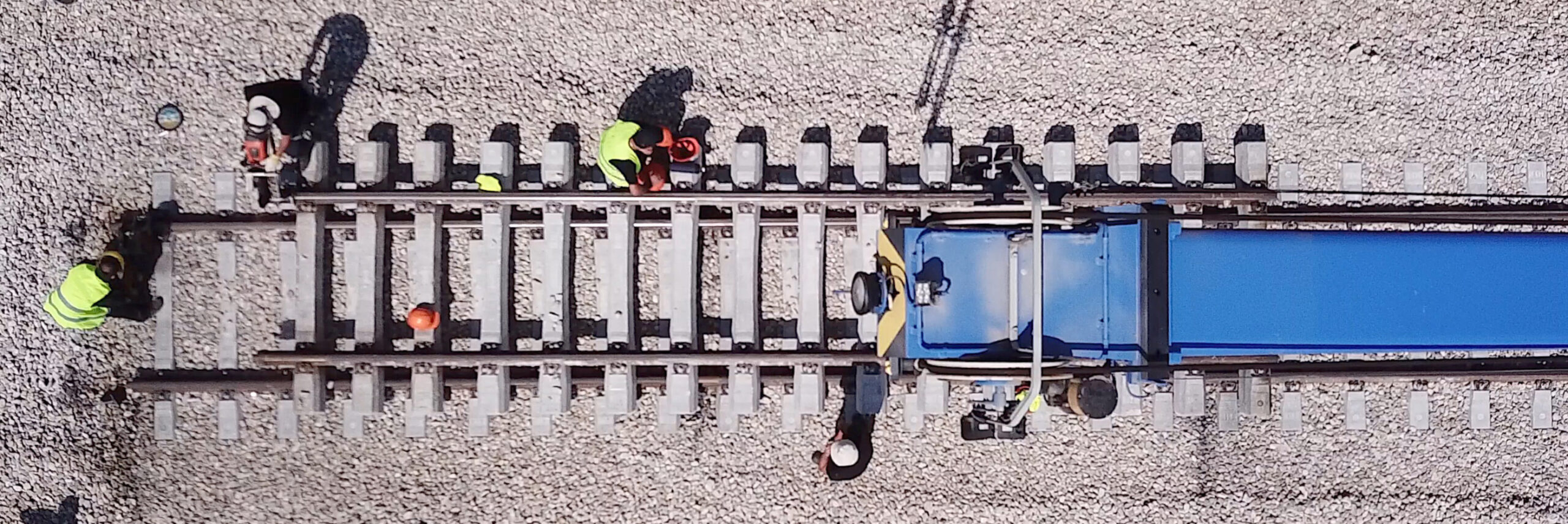 Bailey Brand Consulting - North American Rail Solutions Construction site showing 4 different people working on laying the rails to make up a new train track