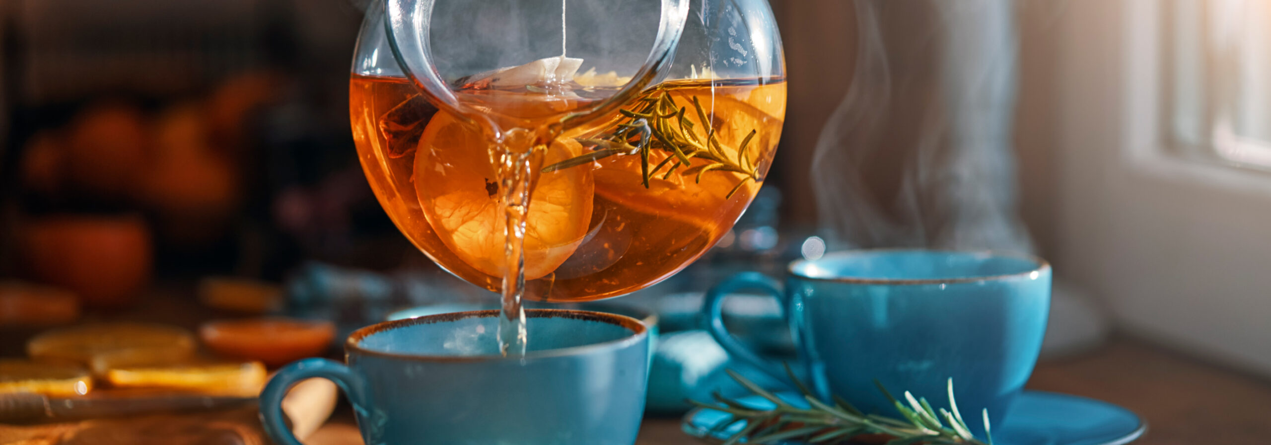 Bailey Brand Consulting - Pot of Twinings Wellness Tea being poured into a blue tea cup on a counter in front of a window